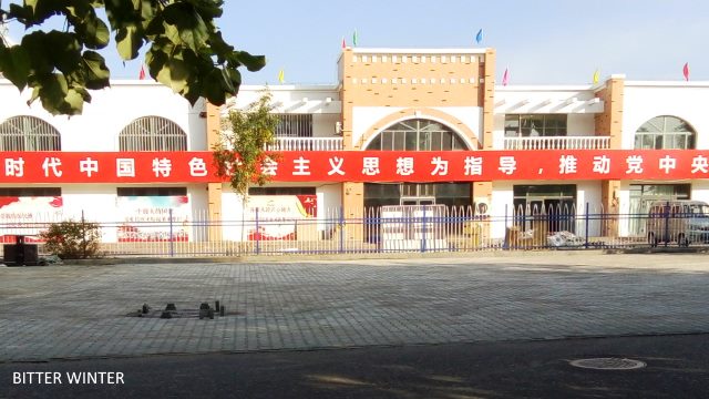 CCP propaganda slogans displayed on the fence of the camp for Uyghur women.