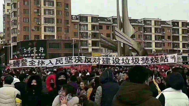 Residents in Teng’ao town raise a banner to protest construction of the garbage incineration station.