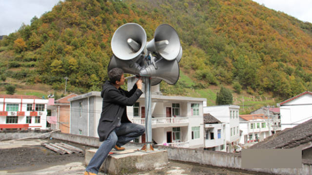 A worker is installing loudspeakers in Zhenping county