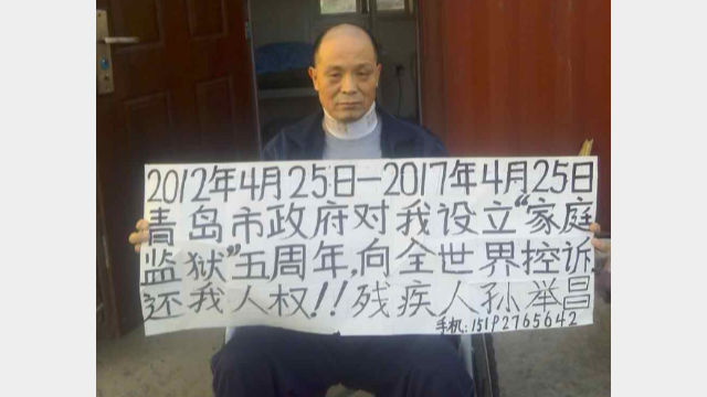 On April 25, 2017, Sun Juchang holds up a sign at his home, appealing to the world to “return my human rights to me.” (supplied by Xin Lin from RFA)