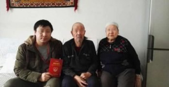 A Han official’s photo with his Uyghur homestay family taken after the signing of “the homestay card”