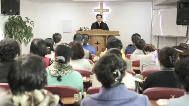 A Korean pastor is giving a sermon
