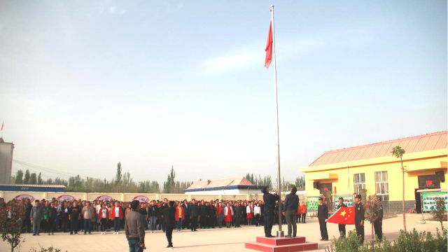 The people in a locality in Xinjiang are organized to hold a flag-raising ceremony