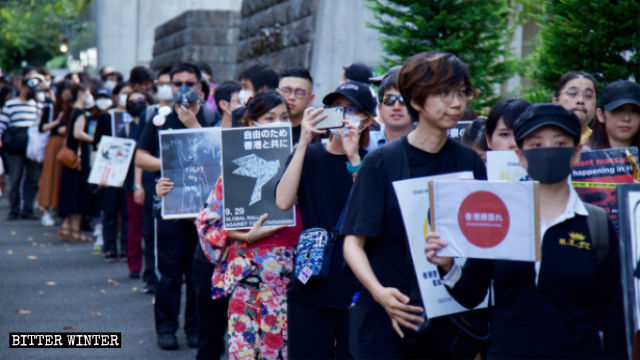 A woman in kimono walks in the anti-totalitarianism march in Tokyo.