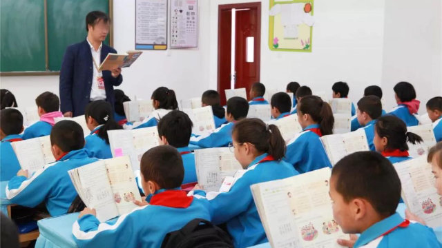 In an experimental primary school in Xinjiang, students are taught to read Chinese textbooks.