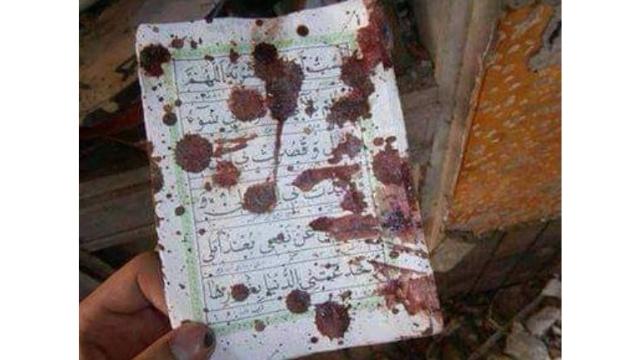 A rescuer shows the blood of the victims on a holy book in the Qissa Khwani Bazaar mosque in Peshawar. From Twitter.