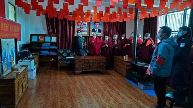 Monks and their bodyguards stand to honor Xi Jinping.