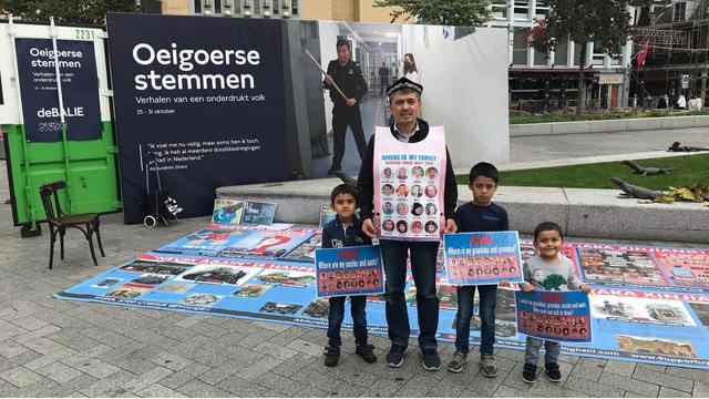 The author Abdurehim Gheni Uyghur with his children at the exhibition.