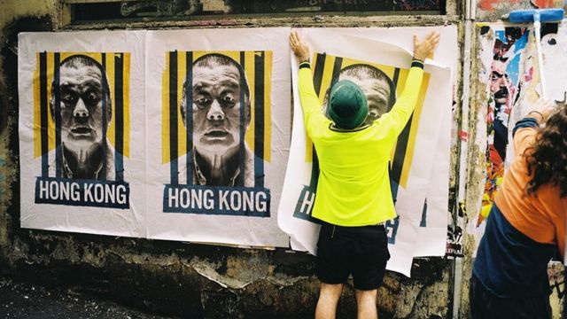 Putting up the poster “Jimmy Lai Behind Bars” in Sydney.