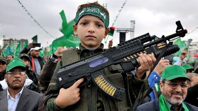 非常に若いハマスの戦闘員が誇らしげに銃を見せている（クレジット）。 ハマスの武器の一部は中国から来ている。