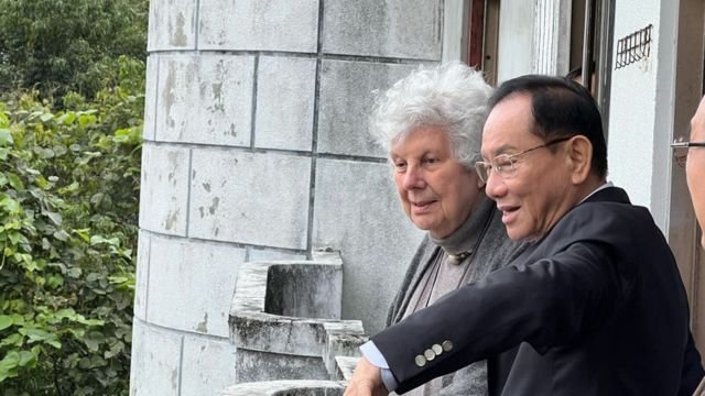 Dr. Hong showing the area to Eileen Barker from the balcony of one of the buildings.