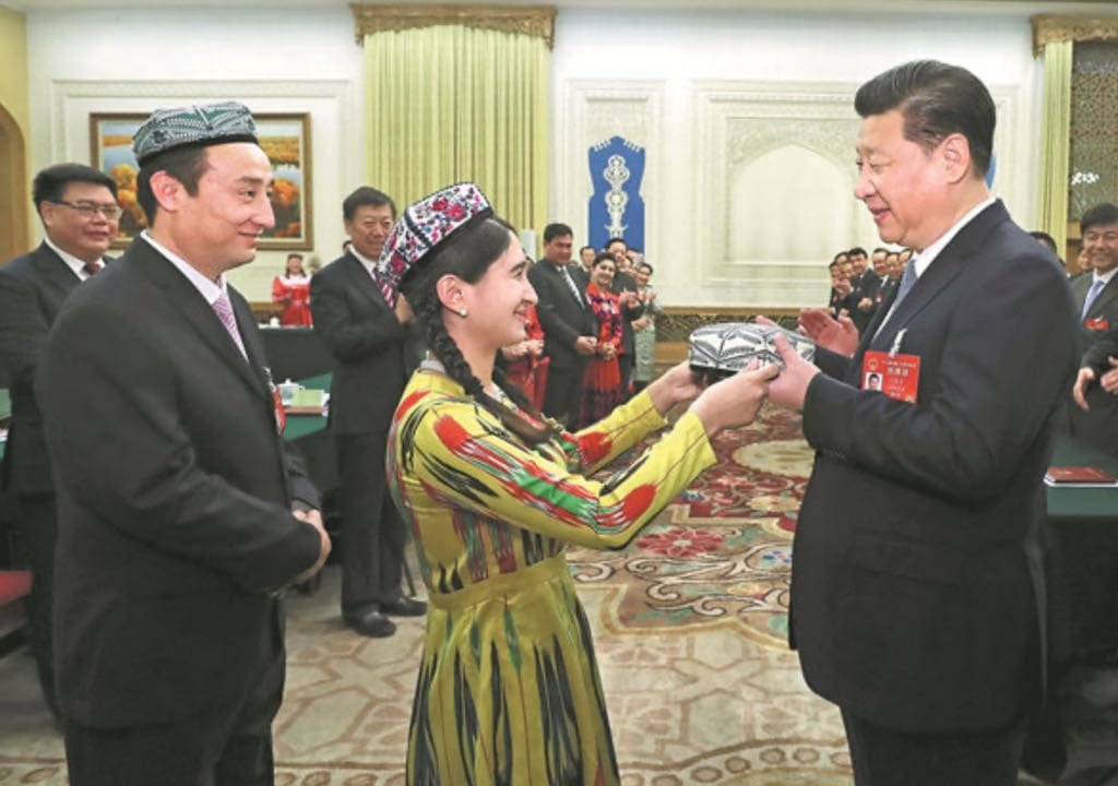 A propaganda image of Xi Jinping receiving gifts of gratitude from Uyghur delegates for his “creative measures.” From Weibo.