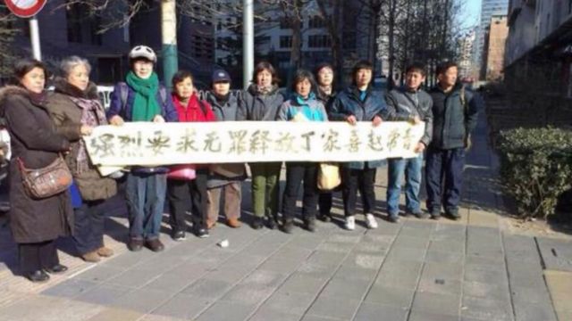 2014年1月21日、勇敢な市民数名が北京の裁判所前で判決が下され、丁嘉熙と共同被告の趙長清の釈放を求める横断幕を掲げた。出典: 中国の人権。