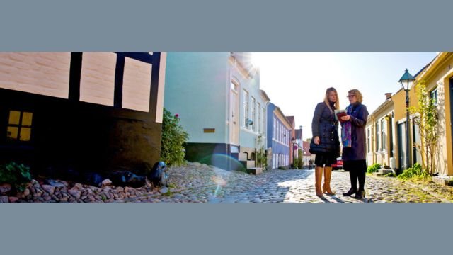 Et Jehovas Vidne viser folderen “Hvad skal der til for at få et godt familieliv?” i Ebeltoft, Danmark. Kilde: JW.org.