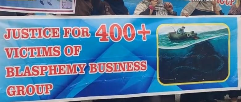 A banner demanding justice for the victims of the blasphemy racket. Screenshot.