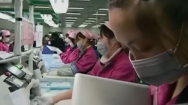 Chinese workers busy manufacturing iPads. Screenshot.