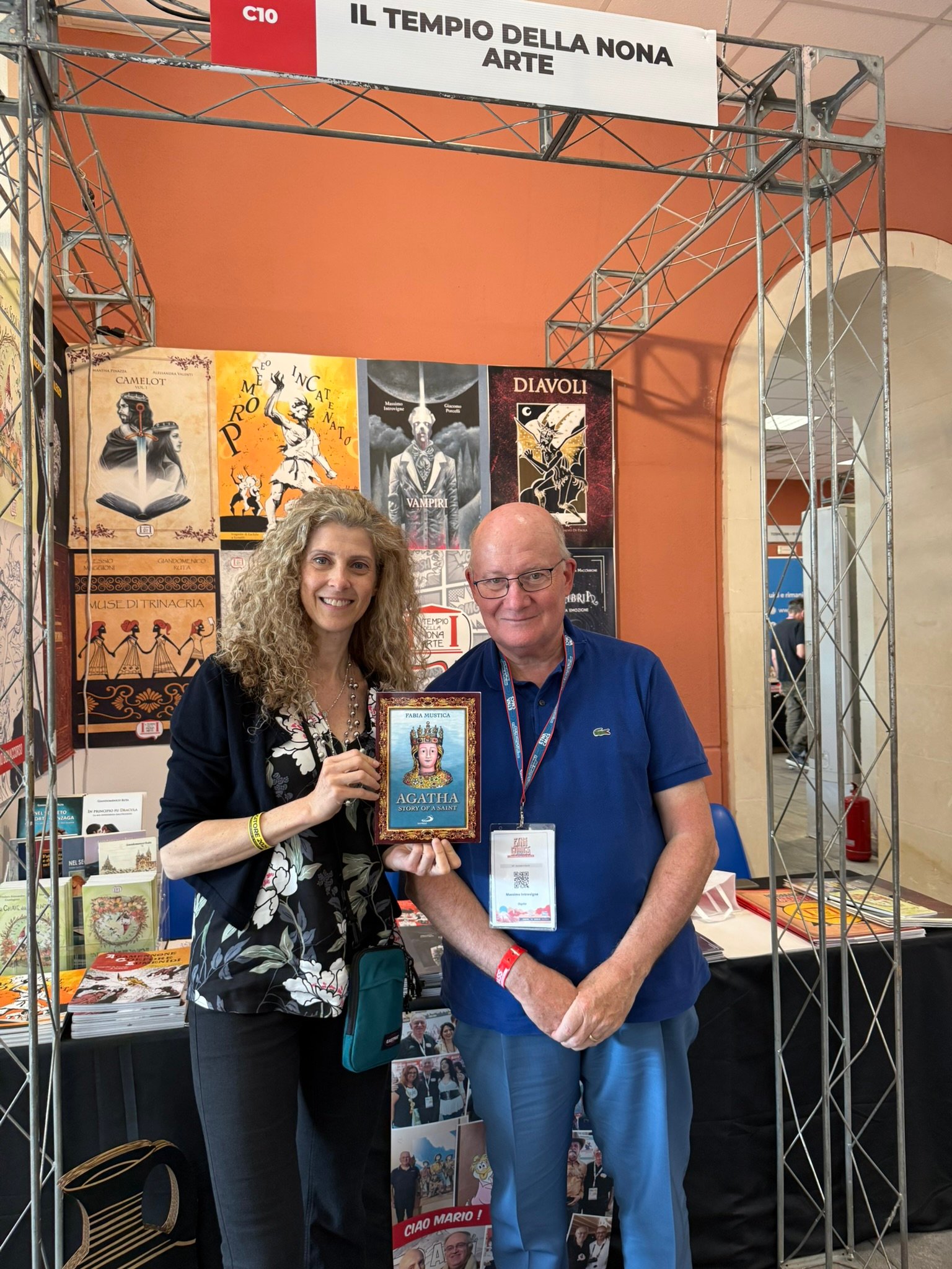 Fabia Mustica with Massimo Introvigne at Etnacomics 2025. They are at the booth of quality comics publisher “Il Tempio della Nona Arte.”