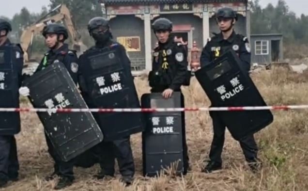 Police confront angry villagers while the demolition proceeds. Screenshot.