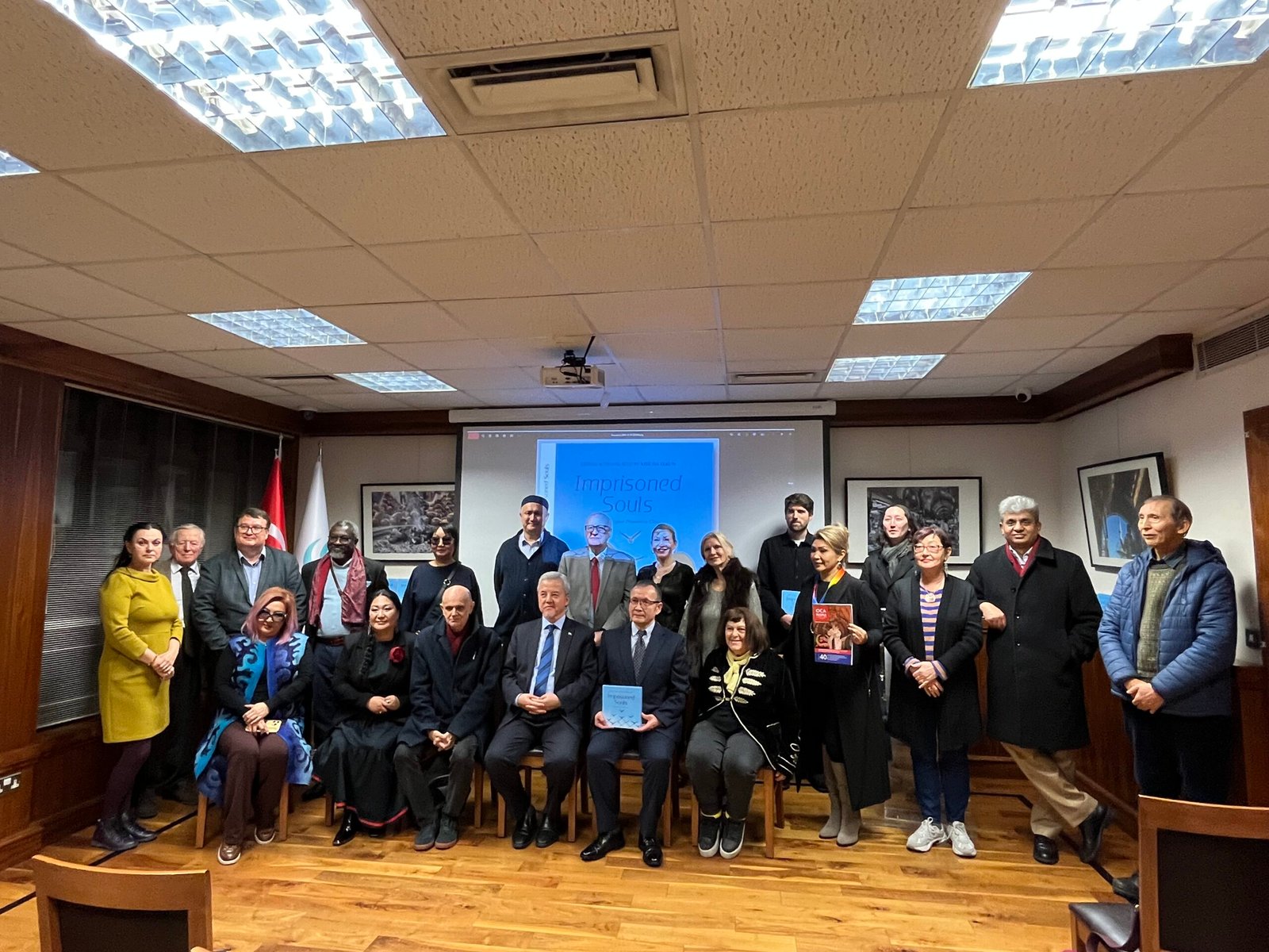 Marat Akhmedjanov, founder and head of Hertfordshire Press, back row, third from left, with some of the attendees at the launch of “Imprisoned Souls.” Author Aziz Isa Elkun, front row centre, is holding a copy. On his left is Turgunjan Alawdun, President of the World Uyghur Congress. Photo by Ruth Ingram.