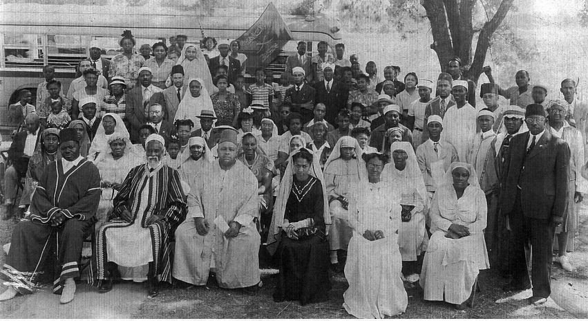 A gathering of the Addeynu Allahe-Universal Arabic Association. Professor Muhamed Ezaldeen (1886&ndash;1957) is the second from the left in the first row, seated. From X.