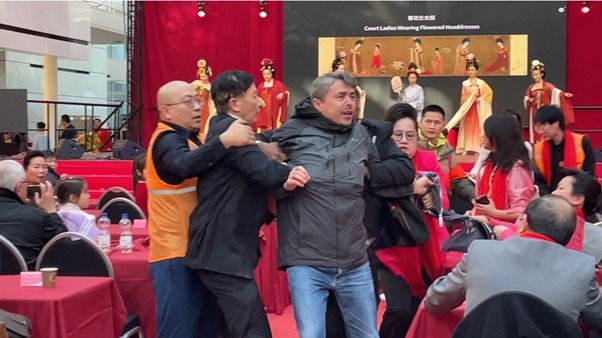 Chinese security personnel try to subdue Abdurehim Gheni Uyghur.