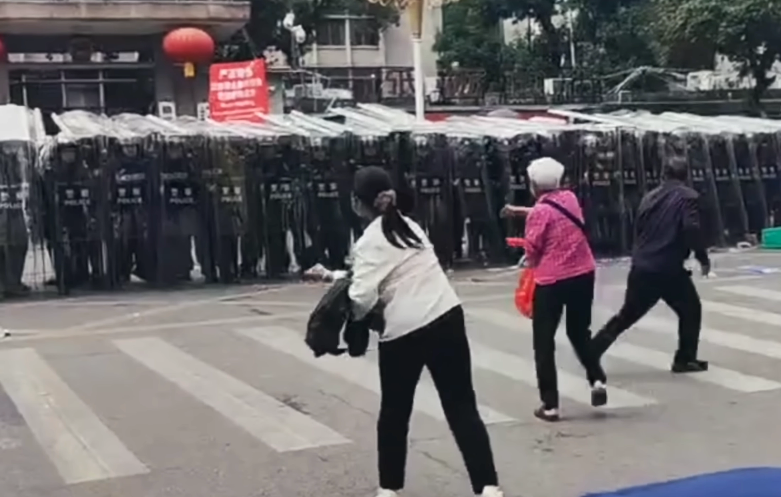 Protesters throw stones at the police in Shuikou Town.