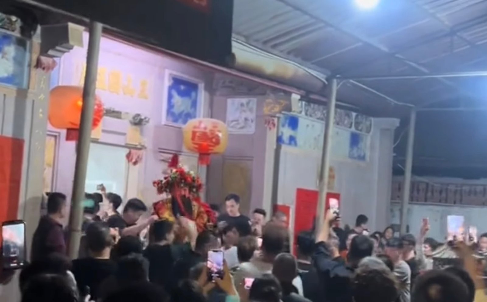 The statue is carried out of the temple, forcing the police blockade.