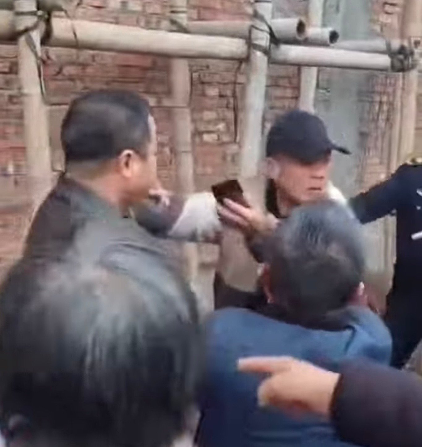 Plainclothes police confront the villagers in Qusha Village.