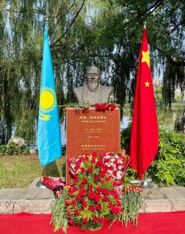 Monument to Abai in Beijing, with Chinese and Kazakh flags.