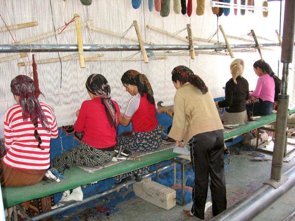 Uyghur women at work in a carpet factory. Credits.