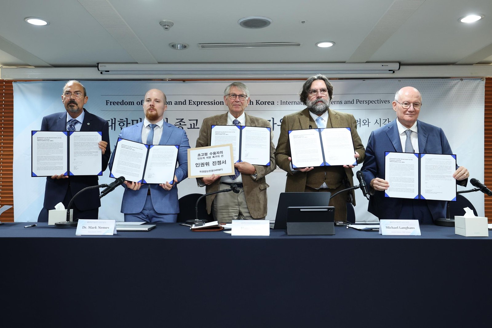 The speakers showing the statement at the press conference.