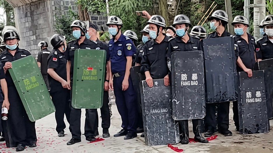 The police try to prevent the entrance to the village. Screenshot.