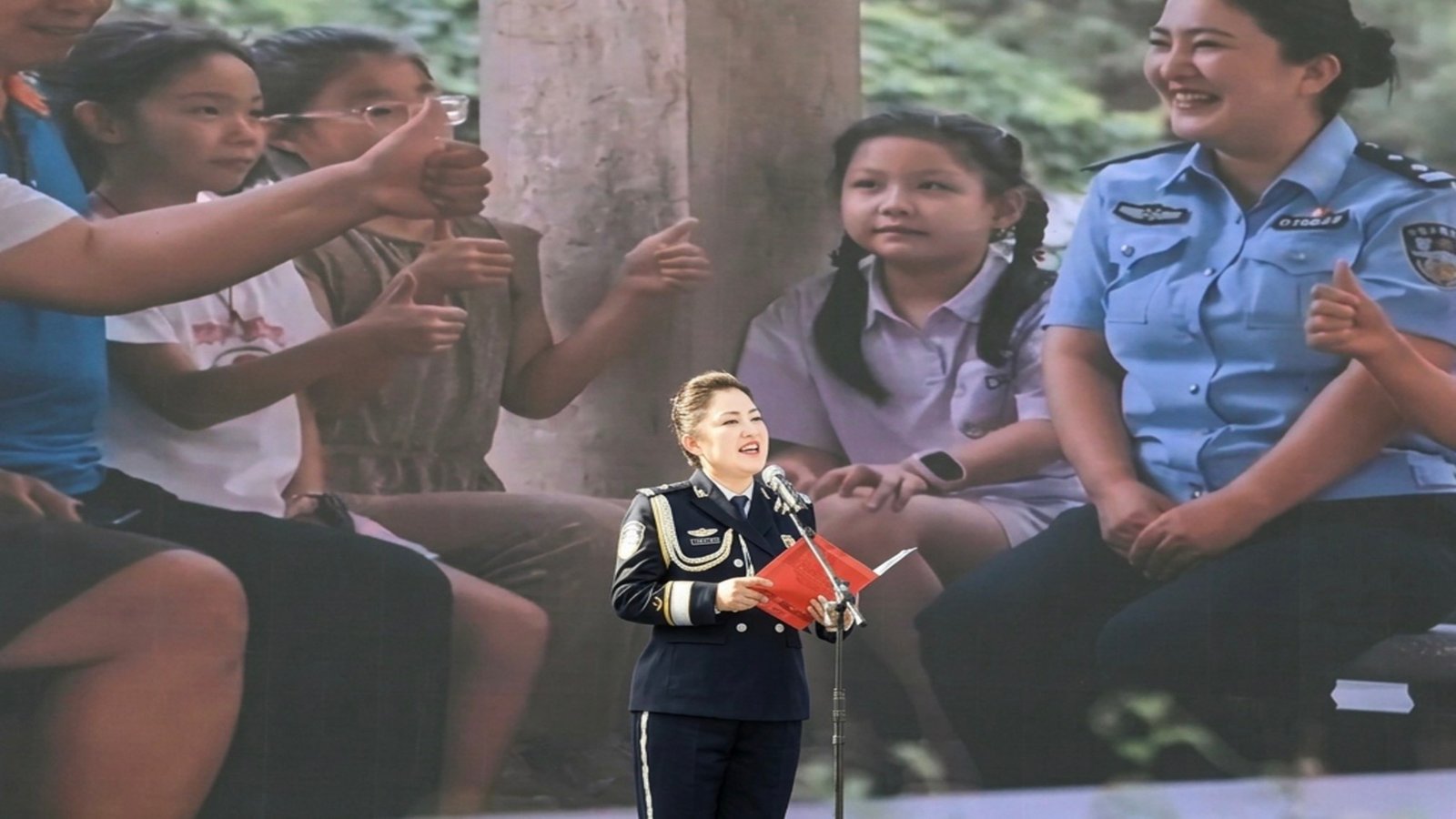 A policewoman explains the new Ethnic Unity Law at the Urumqi opening ceremony. From Weibo.