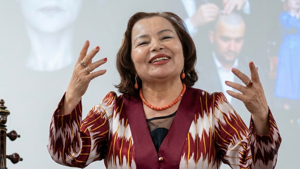 Rahima Mahmut celebrating Uyghur culture in song after the event, against the backdrop of Gulbahar Haitiwaji&rsquo;s book. Credits: Ruth Ingram.
