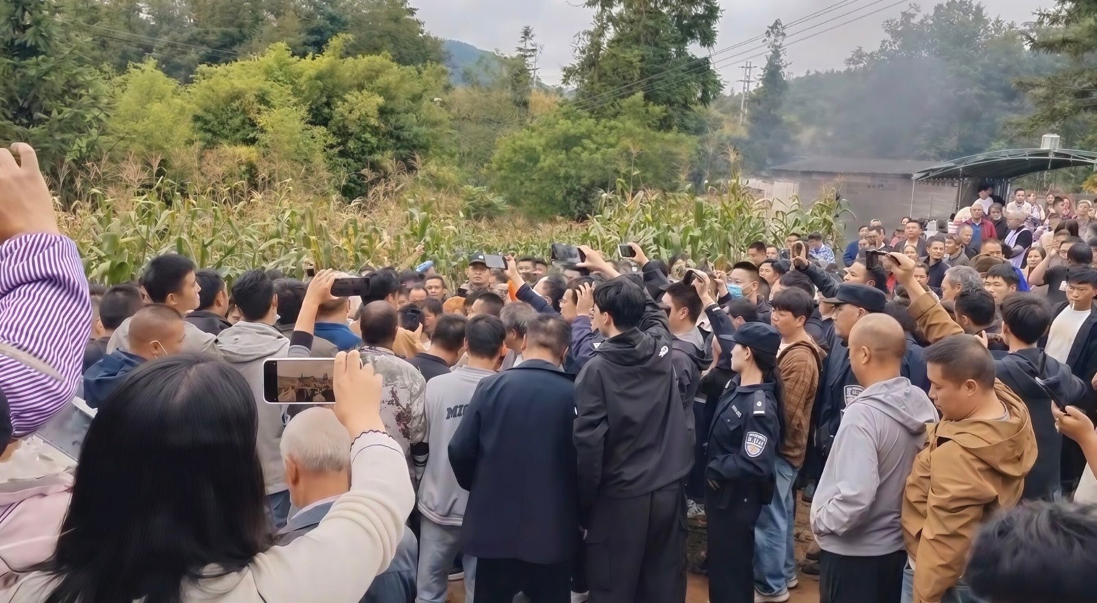 Villagers fight with their weapon of choice: cell phones, ready to post images on social media. Screenshot.